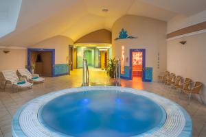 una gran piscina en medio de una habitación con sillas en Kristály Hotel, en Keszthely