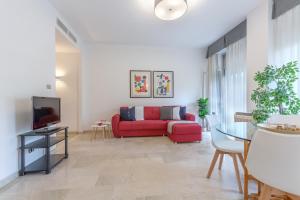 sala de estar con sofá rojo y TV en Ferrara a 5 min dalla Stazione Apartment x5, en Ferrara