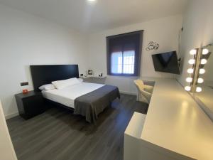 a bedroom with a bed and a desk and a television at Villa Elisa in Nerja +14 photos