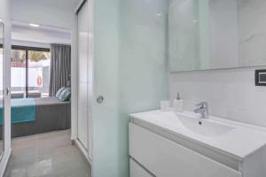 biała łazienka z umywalką i prysznicem w obiekcie Two Dreams Luxury Villa w Corralejo