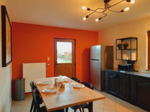 a dining room with a table and a refrigerator at Gite A bicyclette in Dinez