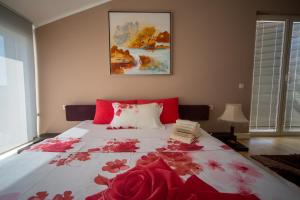 a bedroom with a large bed with red flowers on it at Spa Resort Luxury Apartments in Budva