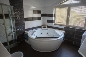 a bathroom with a large tub and a shower at Spa Resort Luxury Apartments in Budva