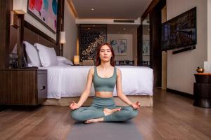 a woman doing a yoga pose in a hotel room at Banyan Tree Kuala Lumpur in Kuala Lumpur