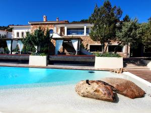 a shell in a swimming pool in front of a house at Hotel delle Rose in Porto Cervo