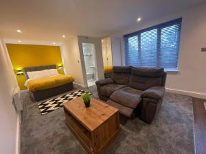 a living room with a couch and a bed at Woodroyd apartments in Luddenden Foot