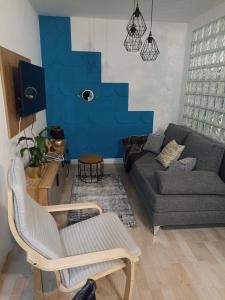 sala de estar con sofá y pared azul en Apartment Close2park ***, en Čakovec