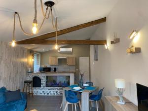 a living room with a table and chairs and a fireplace at Les 4 seasons, agréable gîte avec terrasse et jardin in Croix Bigot