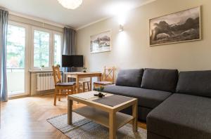 a living room with a couch and a table at Apartamenty na Równi w Centrum Apartzakop in Zakopane
