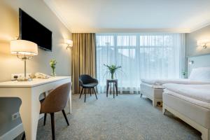 維爾紐斯的住宿－拉頓達中心酒店，配有一张床和一张书桌的酒店客房