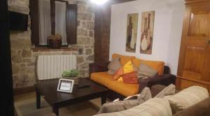 a living room with a couch and a table at La Gesta Picos de Europa in Poo de Cabrales