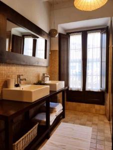 a bathroom with two sinks and a large mirror at La Gesta Picos de Europa in Poo de Cabrales