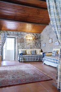 a living room with two couches and a stone wall at Casa dos Limões in Arcos de Valdevez