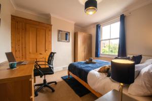 a bedroom with a bed and a desk and a computer at City Centre 3 Bed - Long Stay Offer - Free Parking in Canterbury