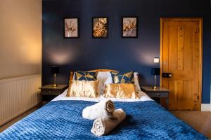 a bedroom with a blue bed with towels on it at City Centre 3 Bed - Long Stay Offer - Free Parking in Canterbury