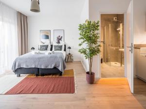 a bedroom with a bed and a potted plant at Limehome Frankfurt Gutleutstraße - Digital Access in Frankfurt/Main