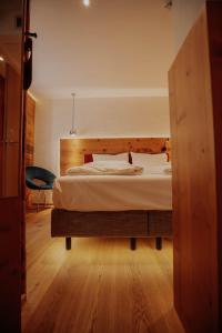 um quarto com uma cama grande e uma cabeceira em madeira em Altstadtmittehotel Sonne em Dinkelsbühl