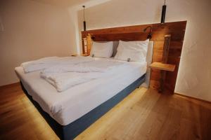 a bedroom with a large bed with a wooden headboard at Altstadtmittehotel Sonne in Dinkelsbühl