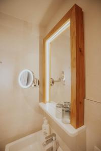 ein Badezimmer mit einem Spiegel und einem Waschbecken in der Unterkunft Altstadtmittehotel Sonne in Dinkelsbühl