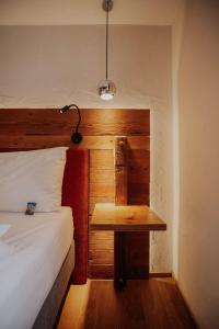 um quarto com uma cama e uma mesa com um candeeiro em Altstadtmittehotel Sonne em Dinkelsbühl