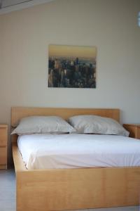 a bed with white sheets and a picture on the wall at Casa Del Mar - Beautiful Two Bedroom Penthouse Apartment in Sainte-Maxime