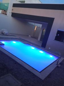 - une piscine avec des lumières bleues dans une maison dans l'établissement Casa Marilago, à Camocim