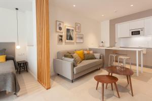 a living room with a couch and a kitchen at Apartamentos Málaga Premium - Calle Granada in Málaga