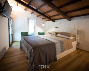 1 dormitorio con 1 cama grande y 2 sillas en Appartamento dell'Arco, en Celleno
