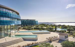 budynek z basenem obok jeziora w obiekcie Falkensteiner Hotel & Spa Iadera w mieście Zadar