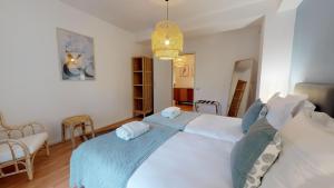 een slaapkamer met een groot wit bed met blauwe lakens bij IMMER 4 chambres 10 personnes in Colmar