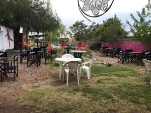 un gruppo di tavoli e sedie in un cortile di Shanti Hostel a San Rafael