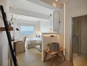 a hotel room with a bed and a bathroom at Vencia Boutique Hotel in Mikonos