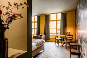 ein Hotelzimmer mit einem Bett und einem Tisch sowie einem Zimmer in der Unterkunft MAF Haarlem Boutique Hotel in Haarlem