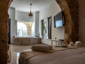 ein Schlafzimmer mit einem Bett und einer Badewanne in einem Zimmer in der Unterkunft סוויטות אושר בגולן in Had Nes