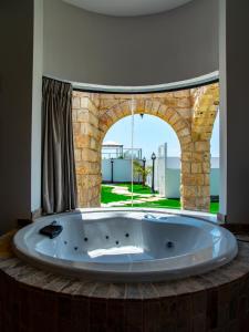 uma grande banheira num quarto com um arco em סוויטות אושר בגולן em Had Nes