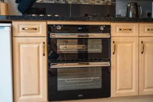- un four noir avec une porte ouverte dans la cuisine dans l'établissement Beautiful Town House with Private Garden and Patio, à Canford Magna