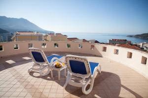 two chairs and a table on a balcony with the ocean at Spa Resort Luxury Apartments in Budva