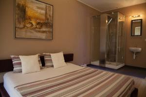 a bedroom with a bed with a glass shower at Spa Resort Luxury Apartments in Budva