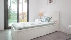 a white bedroom with a large bed with a window at VILLA MEXIC in Llafranc +13 photos