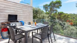 a patio with a table and chairs and a grill at VILLA MEXIC in Llafranc