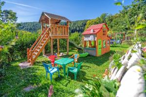 einen Spielplatz mit Stühlen und einem Spielhaus in der Unterkunft Almbauer Morgenbesser in Trattenbach