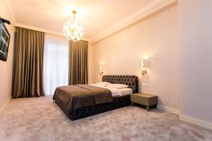 - une chambre avec un lit et un lustre dans l'établissement Rustaveli Residence I, à Tbilissi