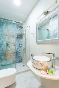 een badkamer met een wastafel en een douche bij Rustaveli Residence I in Tbilisi City