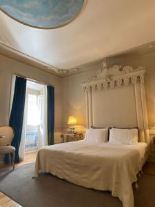 sypialnia z dużym białym łóżkiem i sufitem w obiekcie Mercador w Lizbonie