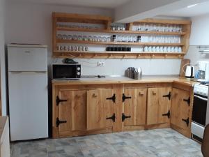 a kitchen with wooden cabinets and a white refrigerator at Karisma Kriss in Suceviţa
