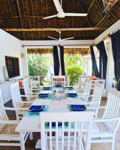 una mesa blanca con sillas blancas y techo en Lion Garden Villas, en Malindi