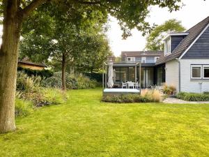 een huis met een tuin met een huis bij Heerlijk vrijstaand huis aan de duinen in Burgh Haamstede