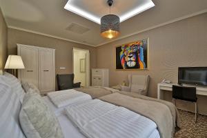 a bedroom with a bed and a flat screen tv at Hotel Pod Bránou in Bardejov