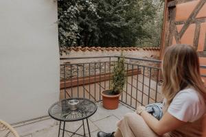 una mujer sentada en un balcón mirando por una ventana en Hotel Gasthaus zur Sonne, en Dinkelsbühl