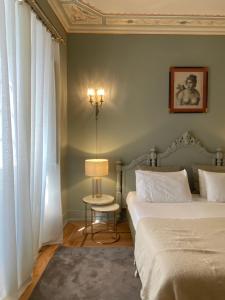 a bedroom with two beds and a table with a lamp at Mercador in Lisbon